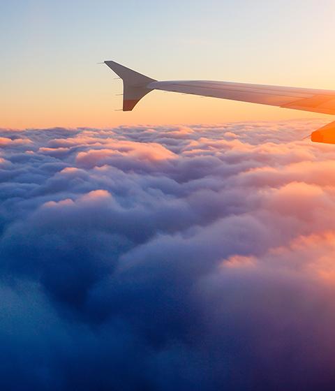 Aile d'avion en vol à partir de la fenêtre, ciel coucher de soleil