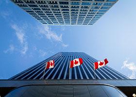 Drapeaux canadiens devant un immeuble commercial