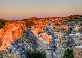 Sunrise shining over the Hoodoo badlands at Writing-on-Stone Provincial Park in Alberta, Canada.